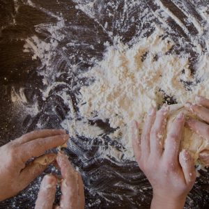hands-making-dough-on-counter